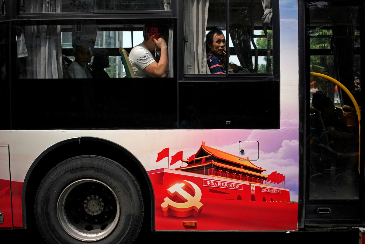 Passengers are seen on a bus, promoting the 19th National Congress of the Communist Party of China (CPC) in Shanghai, China September 26, 2017. Reuters/Aly Song
