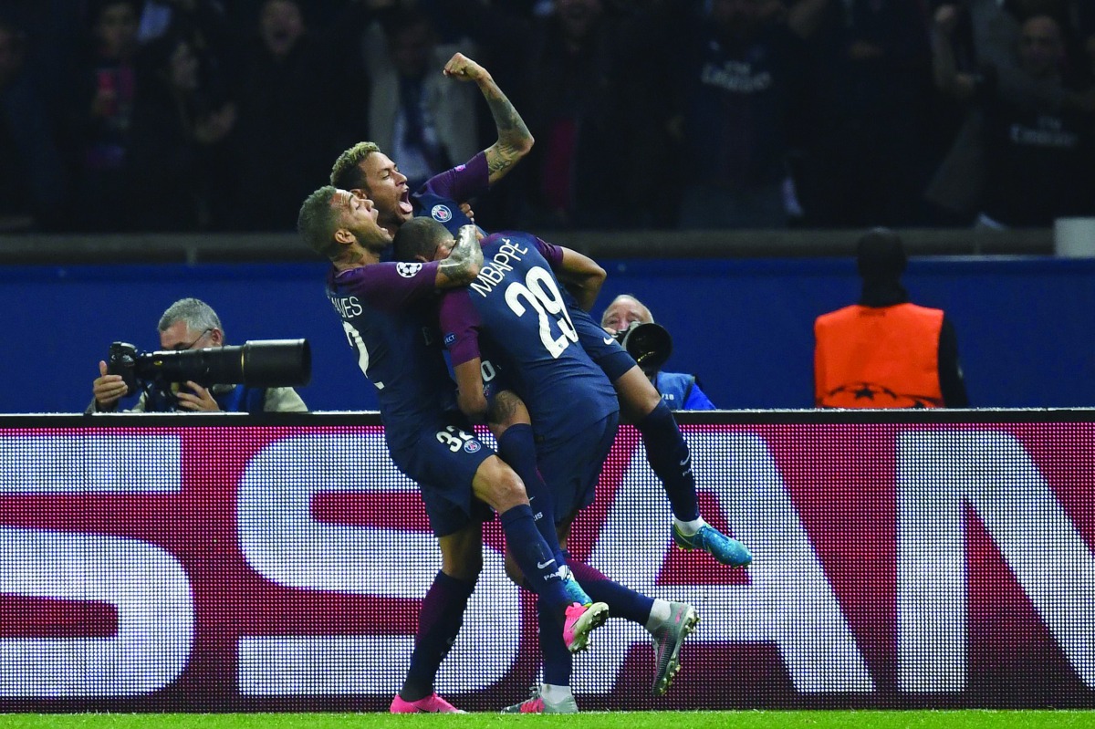 Paris Saint-Germain’s Neymar (centre) is congratulated by team-mates Dani Alves and Kylian Mbappe after he scored a goal during their UEFA Champions League football match against Bayern Munich in Paris yeasterday.