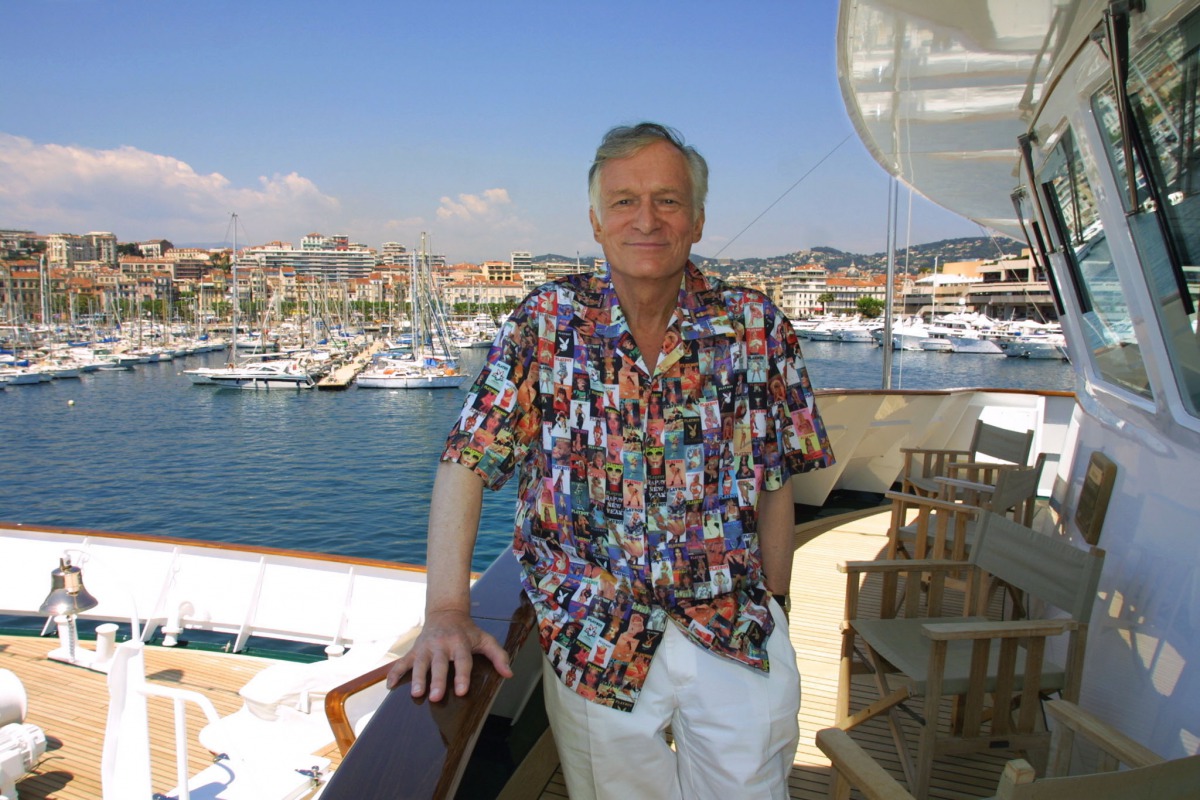 (FILES) This file photo taken on May 12, 2001 shows the US founder and editor-in-chief of Playboy magazine, Hugh Hefner, wearing a shirt with the covers of Playboy magazine on the Esmaralda yatch during the 54th Cannes Film Festival in Cannes, France. AFP