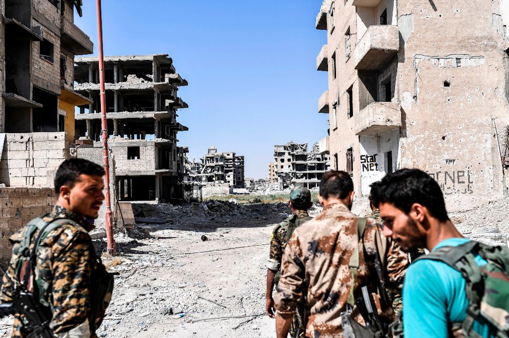 Members of the Syrian Democratic Forces (SDF) advance in a street during a battle against Islamic State (IS) group jihadists to retake the central hospital of Raqa on the western frontline of the city on September 28, 2017.  AFP / BULENT KILIC
