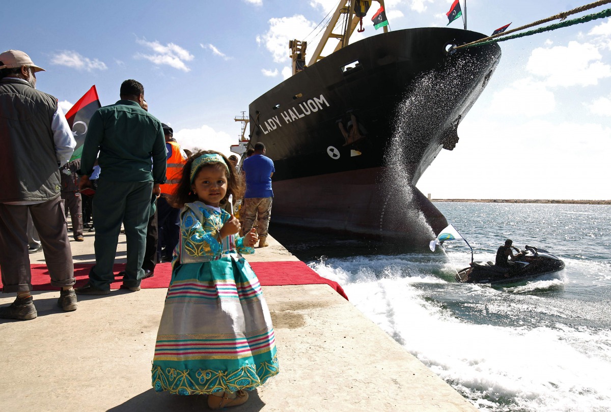 A Libyan girl poses for a photo at the Benghazi port, which was closed for the past three years due to rebel groups occupying the eastern Libyan city, during a ceremony marking the re-opening of the port on October 1, 201. AFP / Abdullah Doma