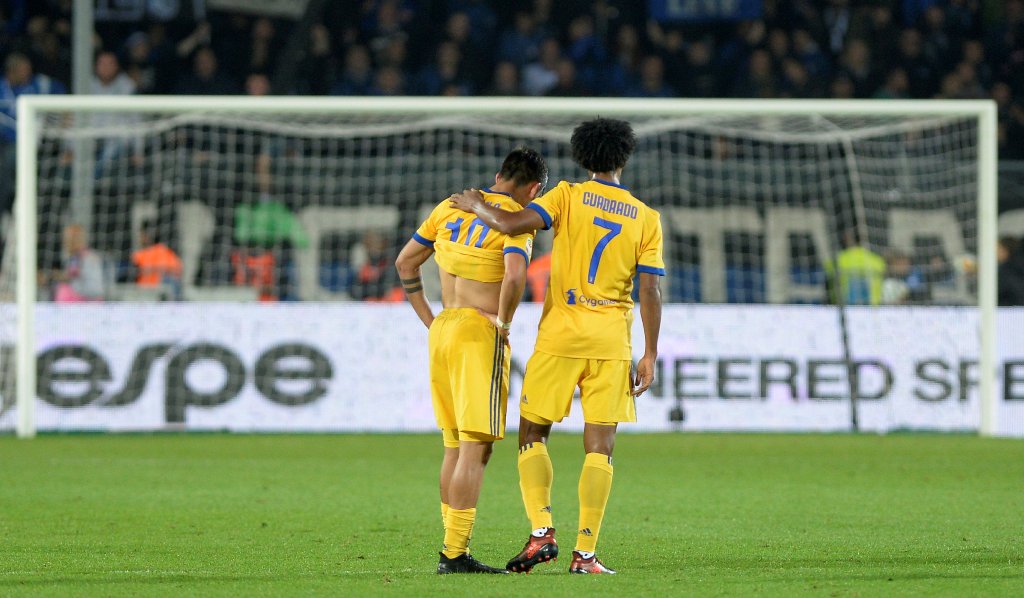 Juventus’ Juan Cuadrado with Paulo Dybala, who looks dejected, at the end of the match REUTERS/Massimo Pinca
