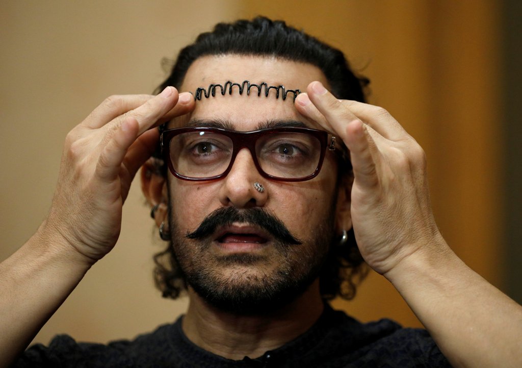 Actor Aamir Khan adjusts his hair during an interview in Singapore October 2, 2017. REUTERS/Edgar Su
