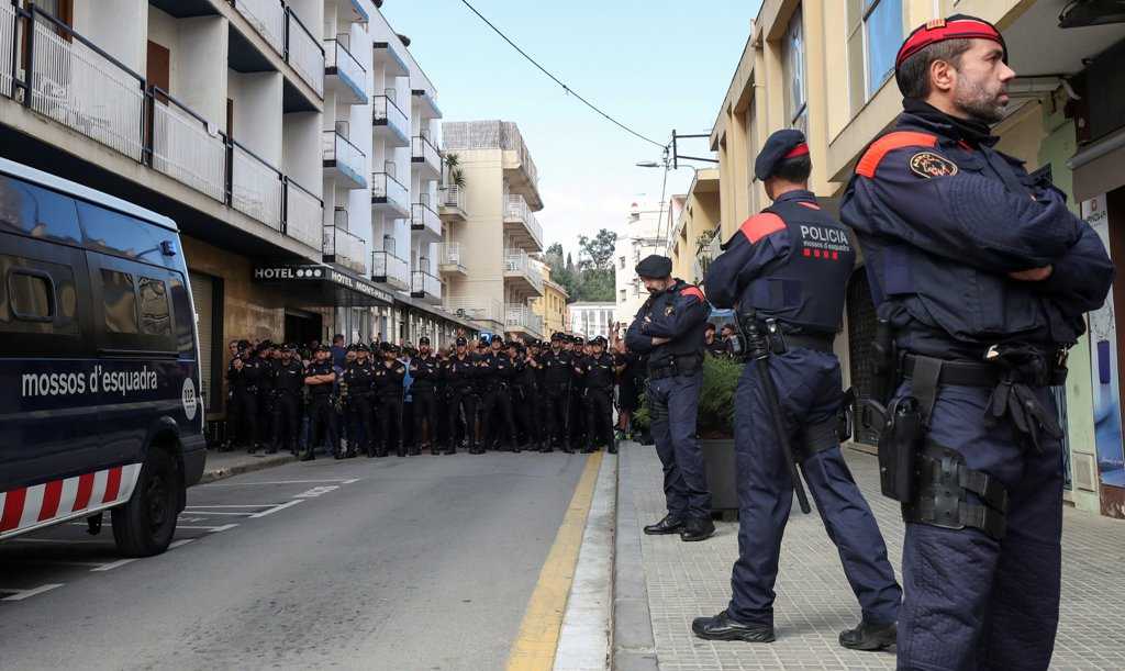 Catalan regional police officers, Mossos d'Esquadra, stand in front of a group of Spanish National Police officers who were shouting towards locals who were protesting the police presence outside their hotel in Pineda de Mar, north of Barcelona, Spain, Oc