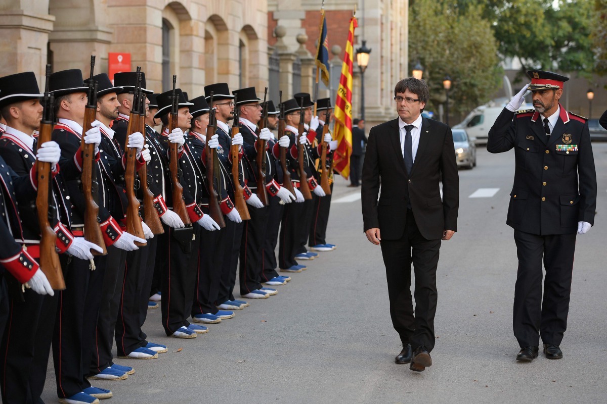 President of the Catalan regional government Carles Puigdemont (2R) and Josep Lluis Trapero (R), chief of the Catalan regional police, inspecting the Mossos D'Esquadra troops before attending an institutional ceremony to award the Mossos d'Esquadra (Catal