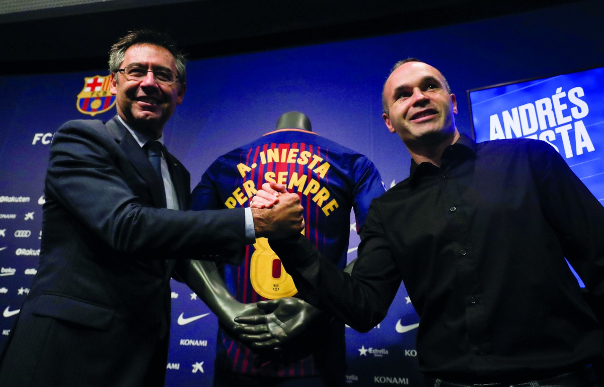 FC Barcelona captain Andres Iniesta (right) shakes hands with club President Josep Maria Bartomeu after announcing the agreement of a contract for life with the Catalan club, yesterday.