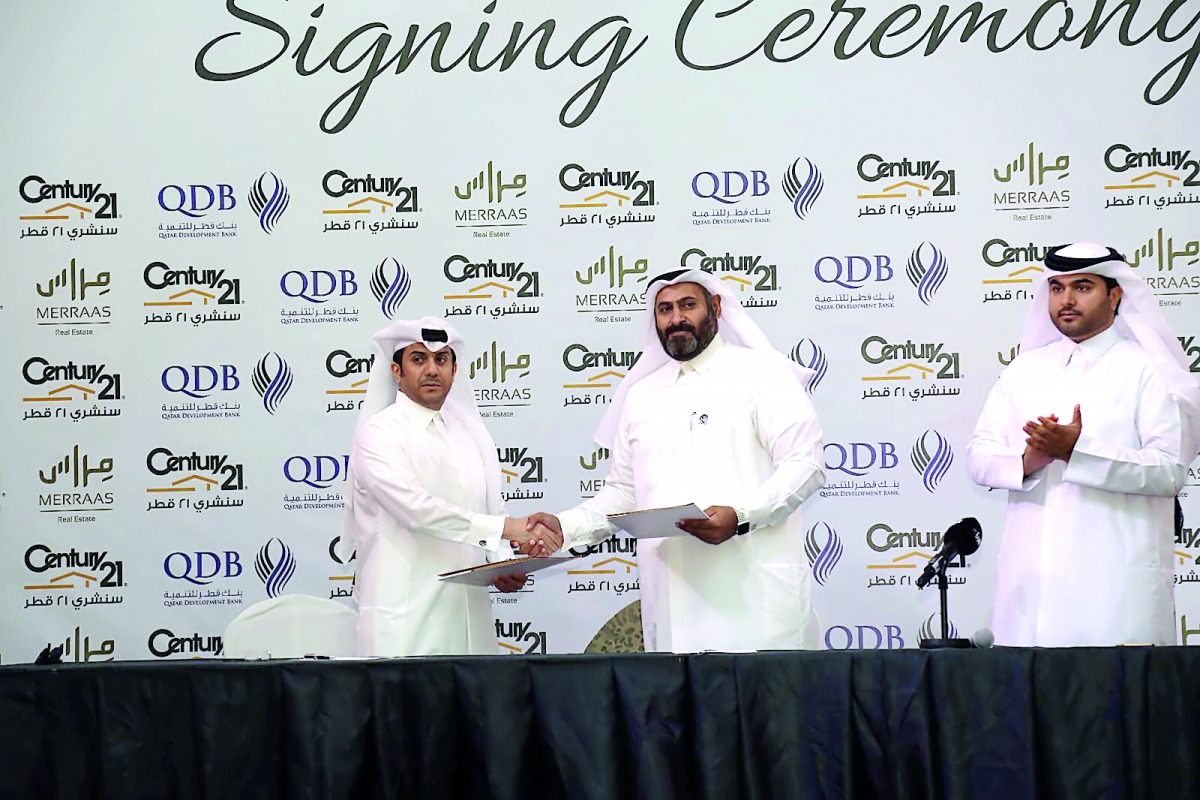 The officials exchanging documents after the signing ceremony.