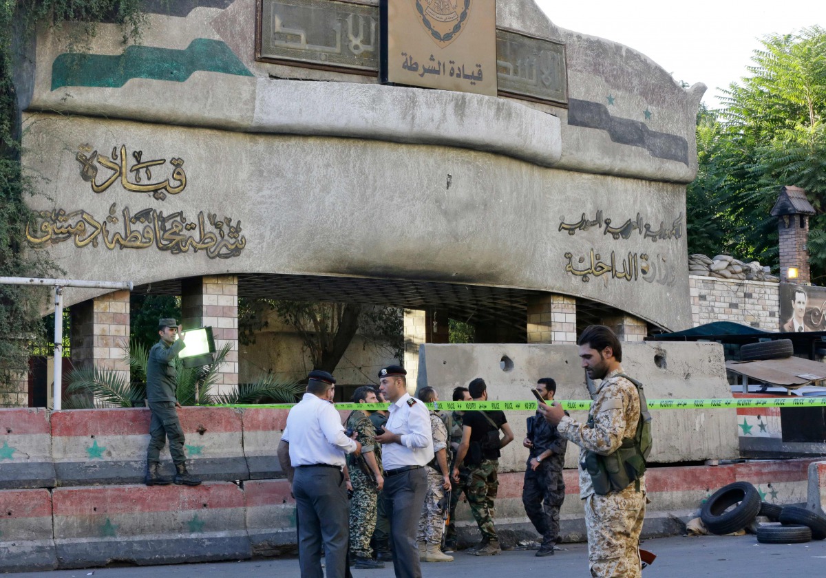 Syrian security forces stand guard outside the main entrance to the police headquarters in Syria's capital Damascus on October 11, 2017, following an attack the targeted the building. AFP / Louai Beshara