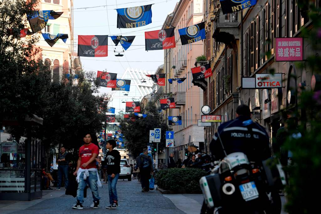 Flags of Italian football clubs Inter Milan and AC Milan are hanged in the Paolo Sarpi street, a chinese neighborhood of Milan, on October 13, 2017.  AFP / MIGUEL MEDINA
