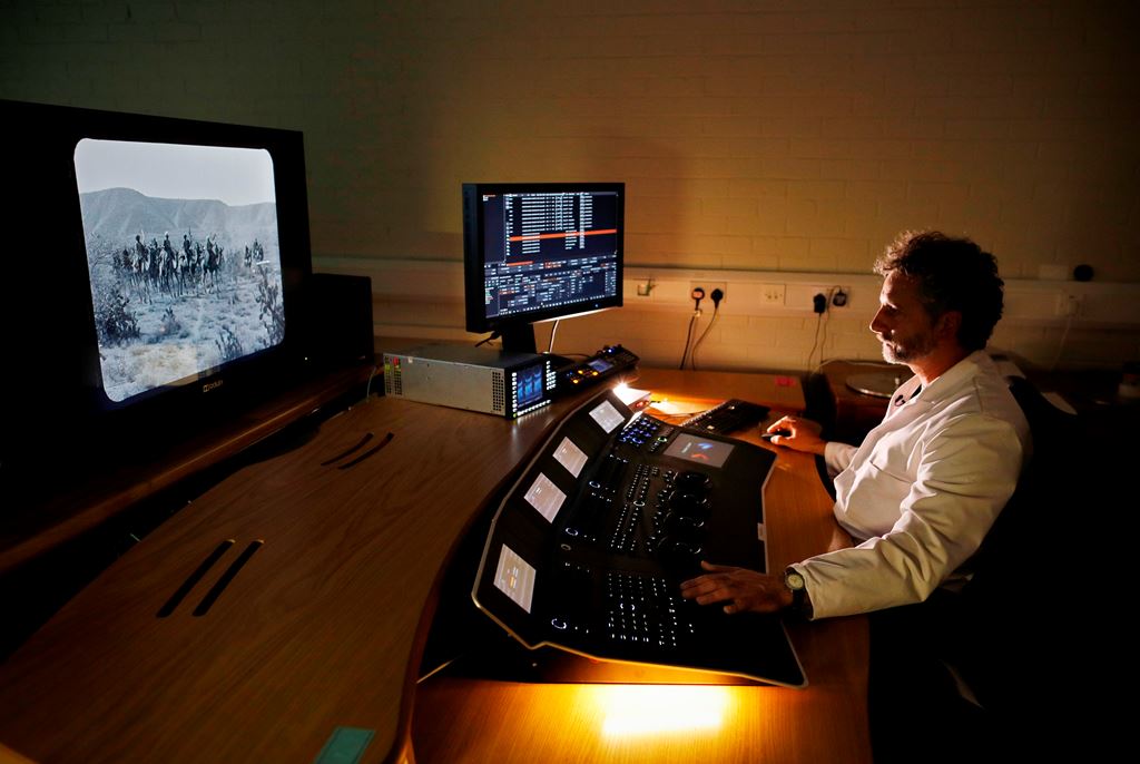 A technician works on a computer to digitally restore individual frames of a film at the British Film Institute (BFI) in Berkhampsted, north of London on October 10, 2017. AFP / ADRIAN DENNIS 
