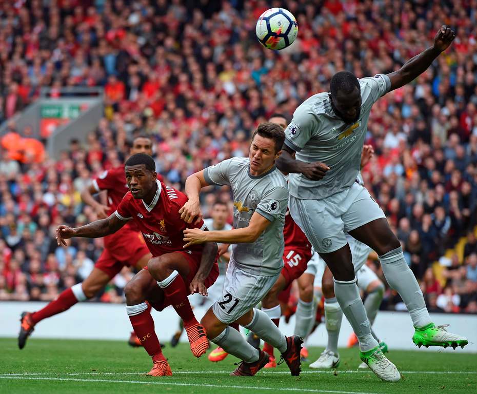 Liverpool's Dutch midfielder Georginio Wijnaldum (L) vies with Manchester United's Spanish midfielder Ander Herrera (C) and Manchester United's Belgian striker Romelu Lukaku (R) during the English Premier League football match between Liverpool and Manche