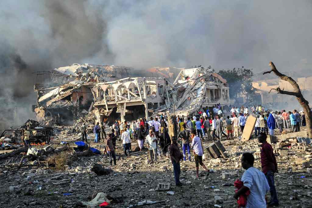 Men and Somalian soldiers arrive on the site to rescue victims of the explosion of a truck bomb in the centre of Mogadishu, on October 14, 2017.   AFP / Mohamed ABDIWAHAB
