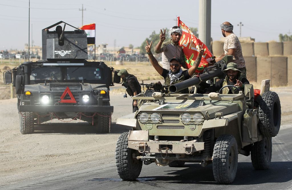 Iraqi forces flash the sign for victory as they advance in the southern outskirts of Kirkuk towards the city during an operation against Kurdish fighters on October 16, 2017.  AFP / AHMAD AL-RUBAYE
