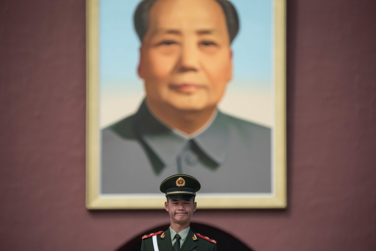 A Chinese paramilitary guard stands in front of a portrait of late communist leader Mao Zedong at Tiananmen Square in Beijing on October 16, 2017. The Chinese Communist Party's week-long, twice-a-decade congress will open on October 18.  AFP / Fred Dufour