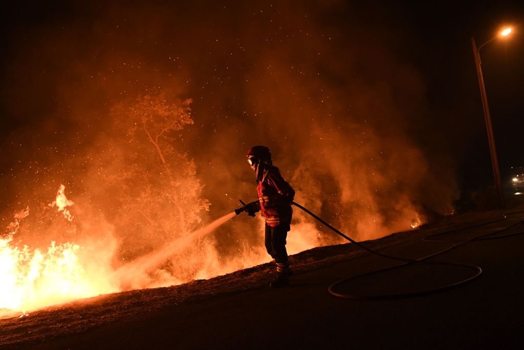 A firefighter tries to extinguish a fire in Cabanoes near Louzan as wildfires continue to rage in Portugal on October 16, 2017.  AFP / Francisco LEONG
