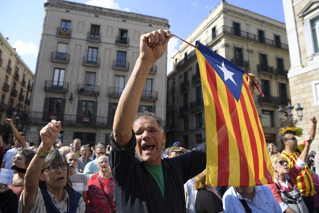A man waves a stelada (pro-independence Catalan flag) during a protest against the arrest of two Catalan separatist leaders in Barcelona on October 17, 2017.  AFP / LLUIS GENE
