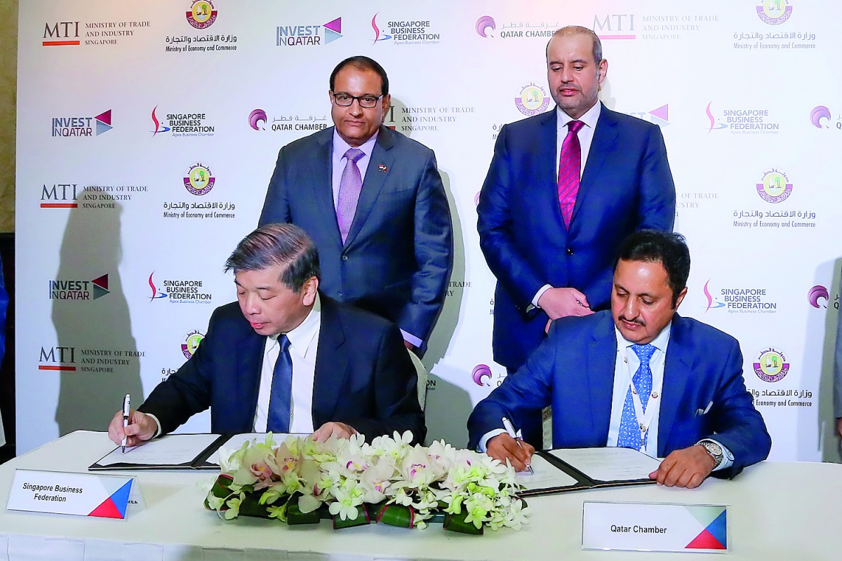 H E Sheikh Ahmed bin Jassim Al Thani (standing right), Minister of Economy and Commerce, and Singapore’s Minister of Trade and Industry, S Iswaran (standing left) witnessing the signing of an MoU between Sheikh Khalifa bin Jassim bin Mohammed Al Thani (si