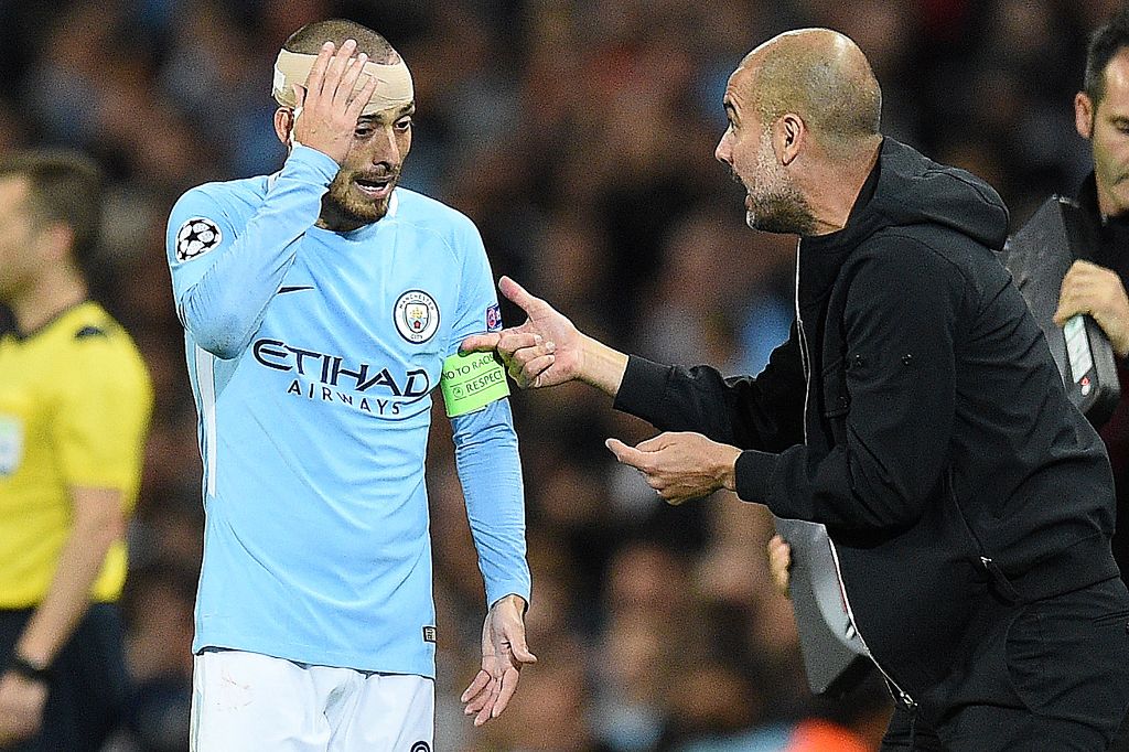 Manchester City's Spanish midfielder David Silva holds his bandaged head as Manchester City's Spanish manager Pep Guardiola gives him instructions during the UEFA Champions League Group F football match between Manchester City and Napoli at the Etihad Sta
