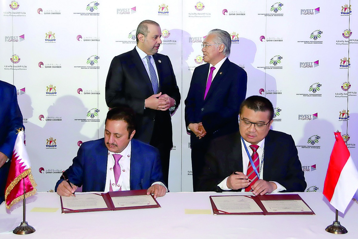 H E Sheikh Ahmed bin Jassim Al Thani (standing left), Minister of Economy and Commerce, and Enggar Lukita (standing right), Indonesian Trade Minister, witnessing the signing of an MoU between Sheikh Khalifa bin Jassim bin Mohammed Al Thani (sitting left),