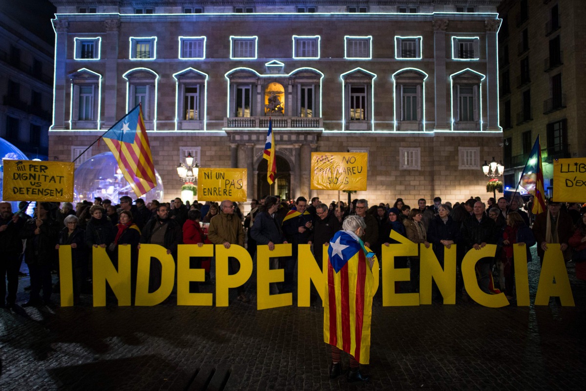 This file photo taken on December 27, 2016 shows Catalan pro-independence supporters holding Catalan pro-independence flags and letters reading 