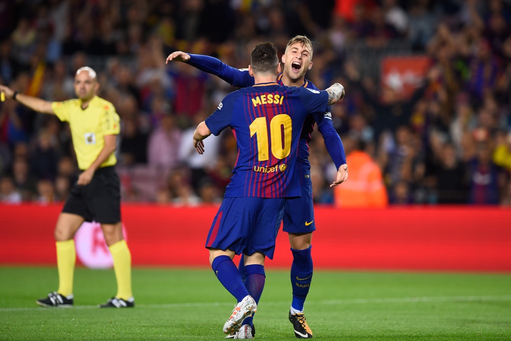 Barcelona's forward Gerard Deulofeu (front) is congratulated by his teammate Barcelona's Argentinian forward Lionel Messi after scoring during the Spanish league football match FC Barcelona vs Malaga CF at the Camp Nou stadium in Barcelona on October 21, 