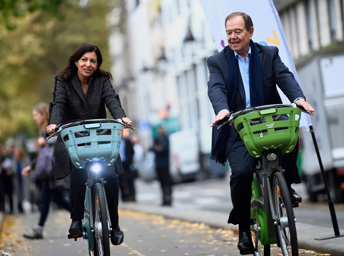 Mayor of Paris Anne Hidalgo (L) and President of Paris Metropole Patrick Oller ride new 
