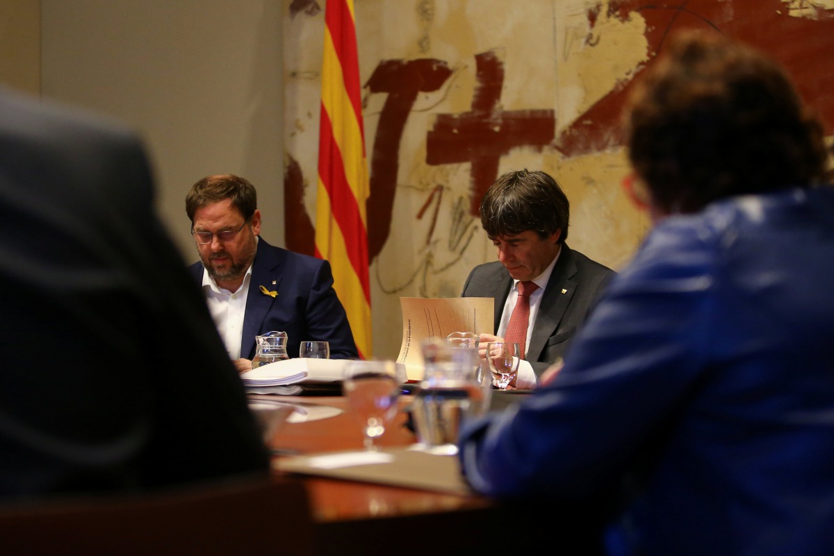 Catalan President Carles Puigdemont (R) and Vice President Oriol Junqueras read documents during a cabinet meeting at Generalitat Palace in Barcelona, Spain, October 24, 2017. Reuters/Ivan Alvarado