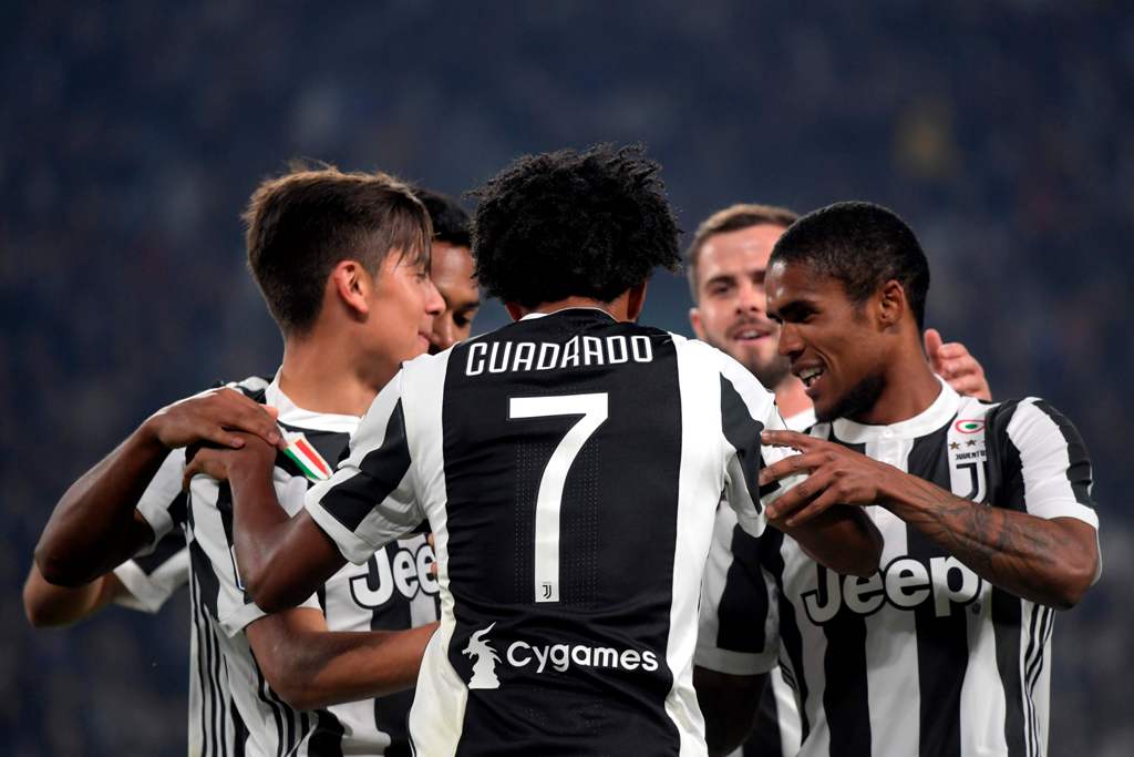 Juventus' Colombian forward Juan Cuadrado (C) celebrates with Juventus' Argentinian forward Paulo Dybala (L) and Juventu's Brazilian forward Douglas Costa de Souza after scoring during the Italian Serie A football match Juventus vs Spal at the Allianz sta