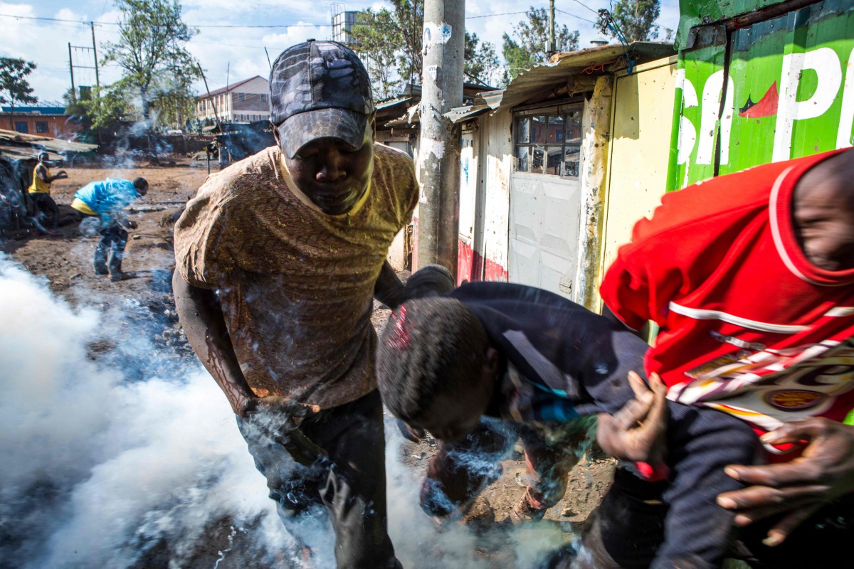A wounded protester is carried away during clashes between opposition supporters and Kenyan police at the Kibera slum in Nairobi on October 26, 2017, after trying to block Olympic Primary polling station during Kenya's re-election voting.  AFP / Patrick M