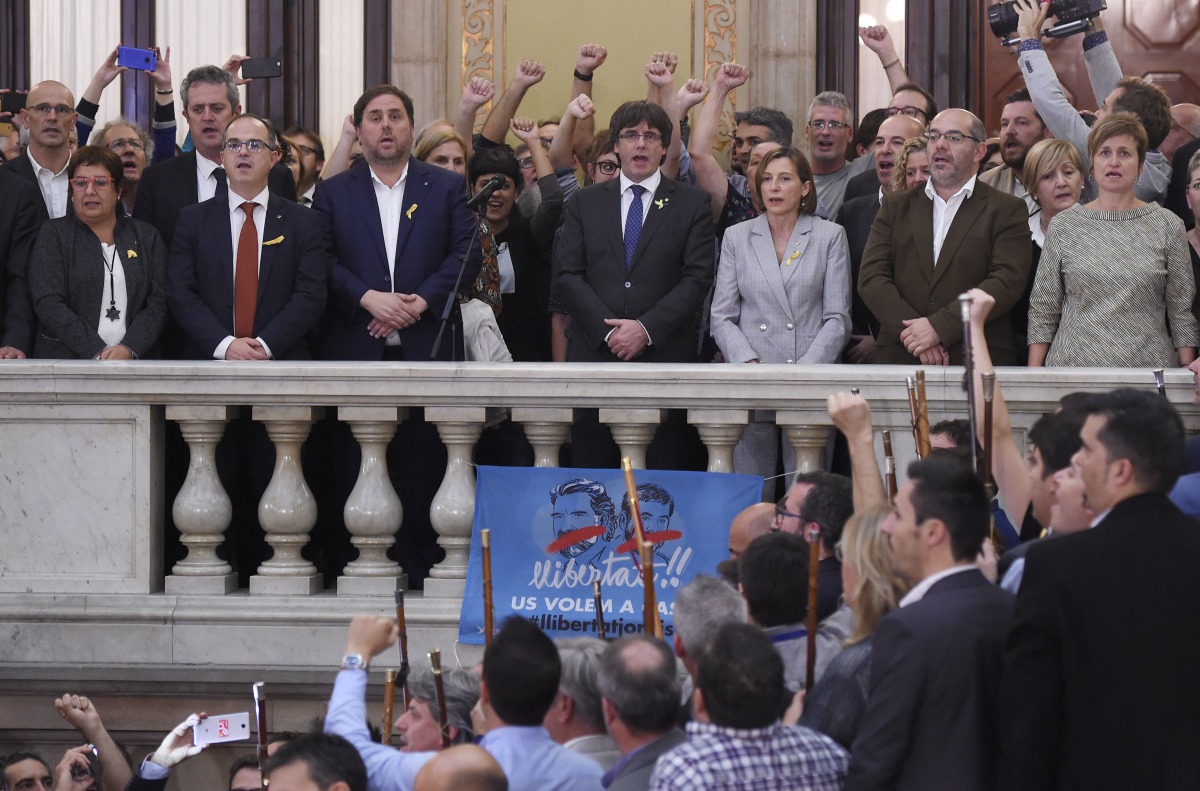 Catala president Carles Puigdemont (C), vice president Oriol Junqueras (L) and president of the Parliament Carme Forcadell (R) sing the Catalan anthem 