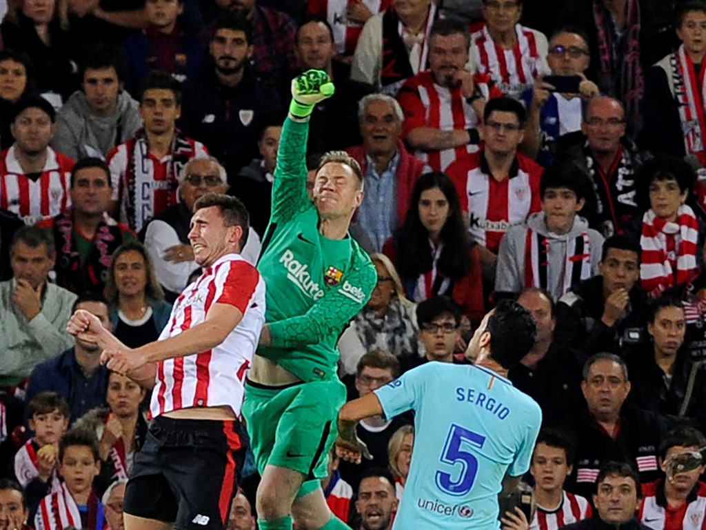 Barcelona's German goalkeeper Marc-Andre ter Stegen (C) vies with Athletic Bilbao's French defender Aymeric Laporte (L) during the Spanish league football match Athletic Club Bilbao vs FC Barcelona at the San Mames stadium in Bilbao on October 28, 2017. /