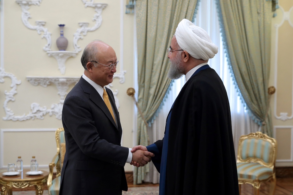 A file photo of a handout picture provided by the office of Iranian President Hassan Rouhani on October 29, 2017 shows him (R) greeting Director General of the International Atomic Energy Agency (IAEA), Yukiya Amano (L) ahead of their meeting in Tehran. A
