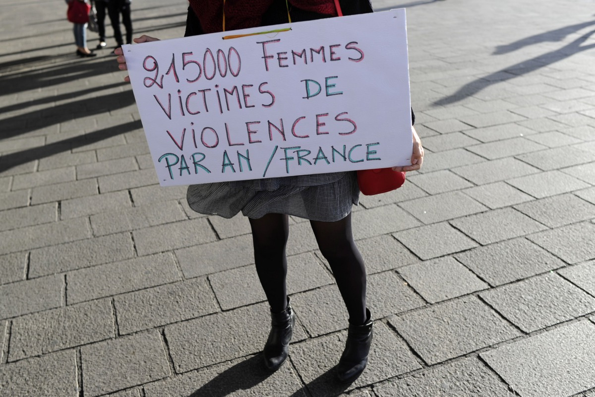 A woman holds a placard reading '21500 women victims of violence per year in France' as people gather for a rally at the Old Port of Marseille, southern France, on October 29, 2017, to denounce harassment and sexual violence in everyday life. Hundreds of 