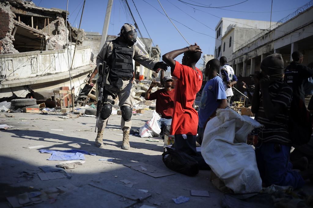 (FILES) This file photo taken on January 15, 2010 shows a Haitian policeman arresting looters on a street of Port-au-Prince, three days after an earthquake measuring 7.0 on the open-ended Richter scale hit the Haitian capital. AFP / Olivier Laban-Mattei 