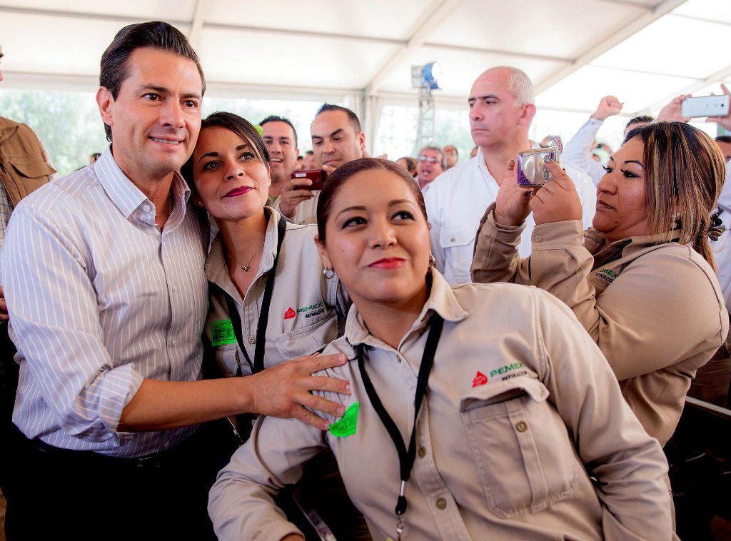 This handout picture released by the Mexican presidency shows Mexican President Enrique Pena Nieto (L) with workers of the state-run PEMEX oil company in Tula, Tamaulipas state, Mexico on November 3, 2017. On Friday, Pena Nieto announced the discovery of 