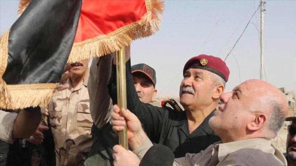 Iraqi Prime Minister Haider al-Abadi (R) hangs an Iraqi flag during his visit Qaim town and Husaybah border gate, newly-liberated town from IS terrorists, in Anbar, Iraq on November 5, 2017. ( Iraq Prime Ministry Press Office - Handout - Anadolu Agency ).