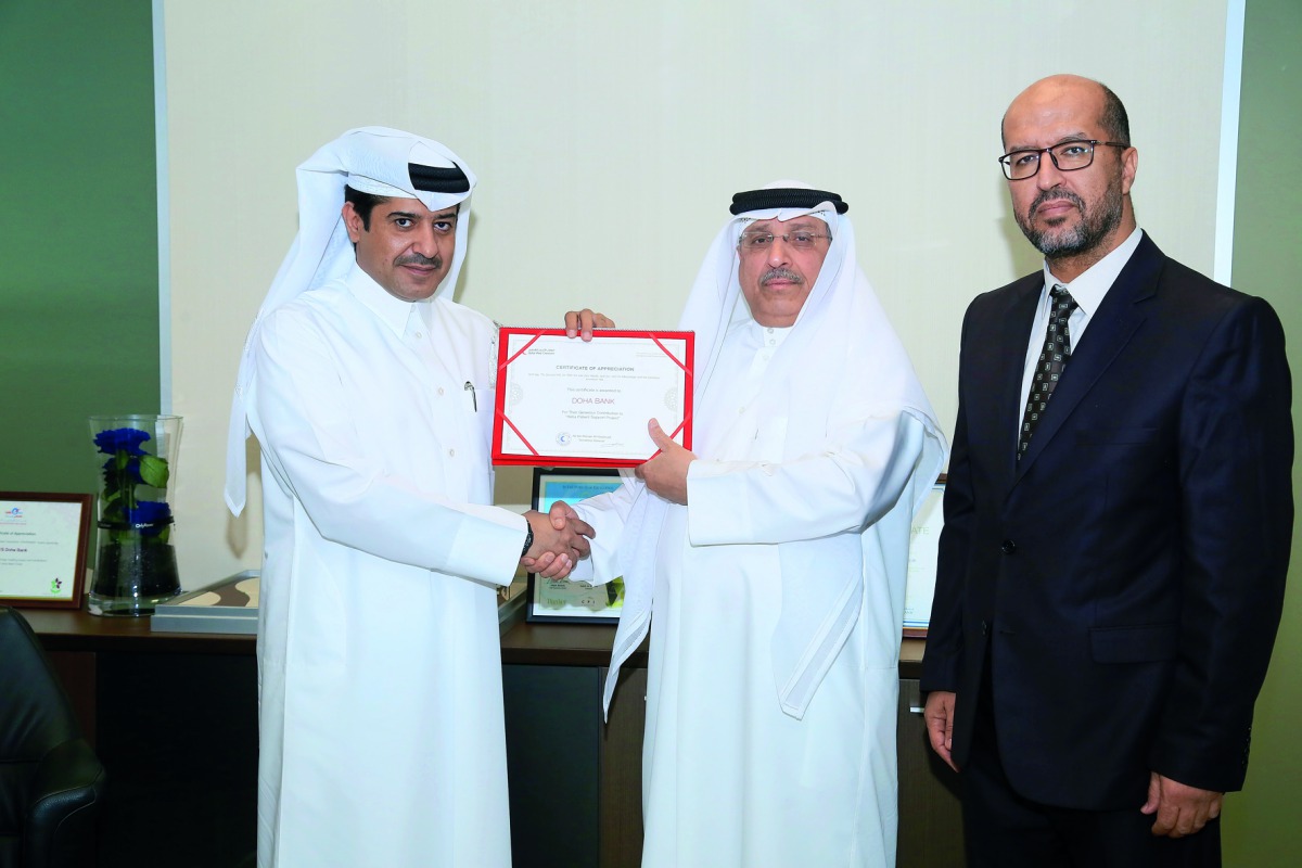 Ahmed Al Henzab (left), Head of Administration and Properties, Doha Bank;  handing over the aid to Saad Shaheen Al Kaabi (centre), Director of Resource Mobilisation Department; and Hamid Moharrar, Head of Corporate Relations at QRCS. 
