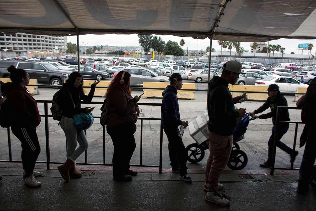 People line up on the pedestrian crossing lines on the Mexican side of the San Ysidro Port of Entry on November 1, 2017, in Tijuana, northwestern Mexico. AFP / GUILLERMO ARIAS