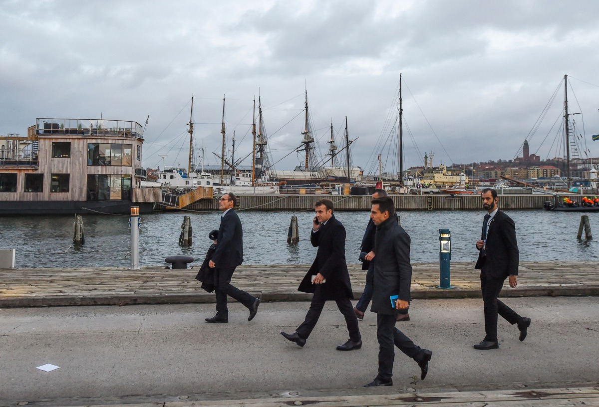 France's President Emmanuel Macron (2L) speaks on his cell phone while leaving the luncheon during the European Social Summit in Gothenburg, Sweden, on November 17, 2017. AFP / Jonathan Nackstrand
