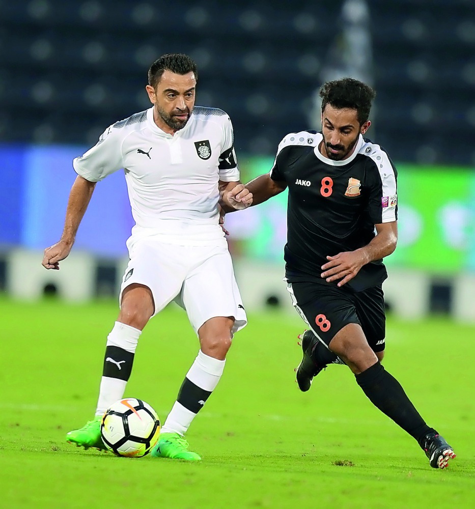 Al Sadd’s Xavi Hernandez (left) vies for ball possession with Umm Salal’s Adel Alawi Al Soleymani during their QNB Stars League match at Al Sadd Stadium yesterday. Al Sadd won 4-1.