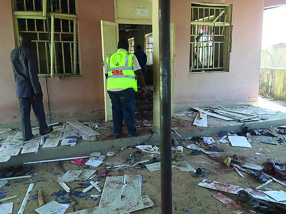 A National Emergency Management Agency (NEMA) staff inspects the damage at the site of a suicide bomber attack in Mubi in Adamawa state, yesterday.
