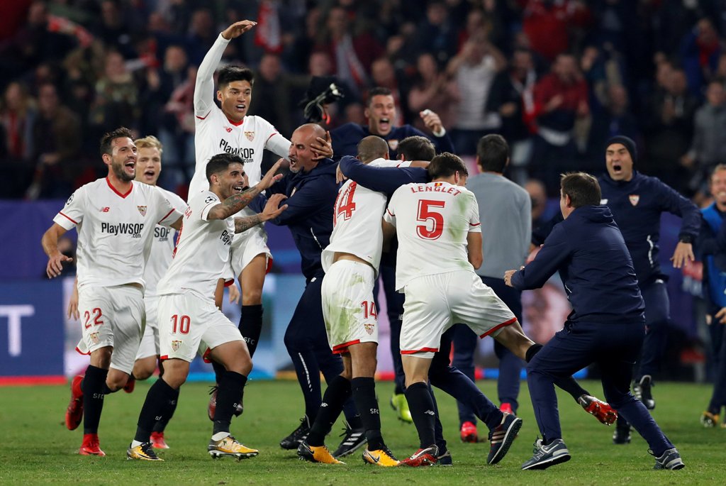 Sevilla’s Guido Pizarro celebrates scoring their third goal with coach Eduardo Berizzo and team mates. Reuters/Matthew Childs
