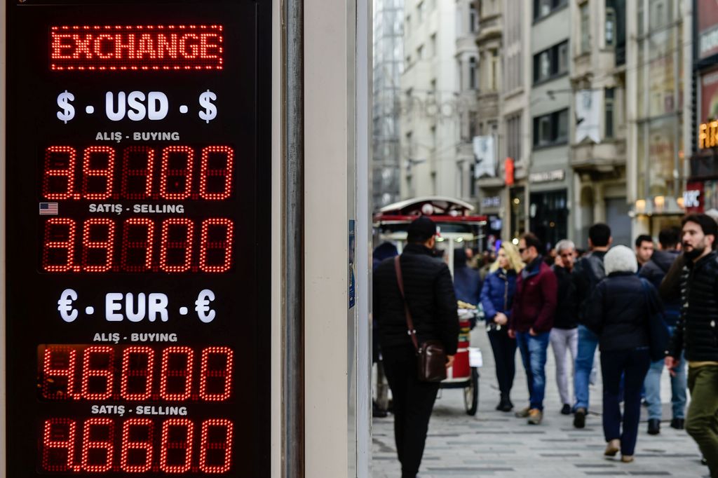 People stay in frot of a money exchange office on November 21, 2017 in Istanbul. The Turkish lira hit record lows in value against the US dollar on November 21 as investors took fright over an impending trial in the United States and changes to banking re