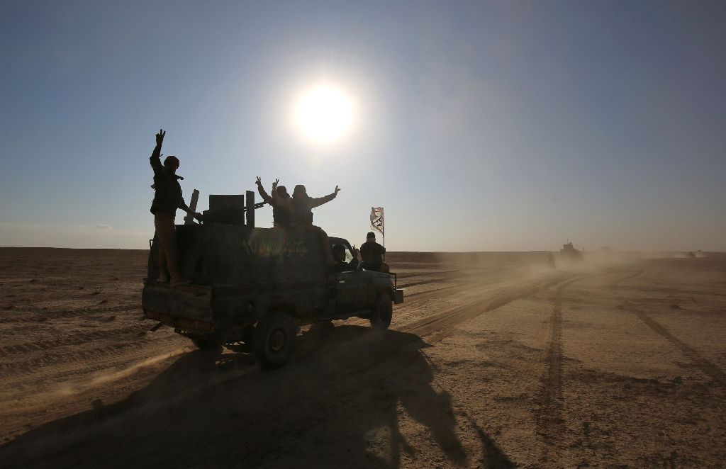 Iraqi forces, supported by members of the Hashed al-Shaabi (Popular Mobilisation units), advance through the Salaheddin province in the western desert bordering Syria after leaving the town of Baiji, on November 24, 2017, as they attempt to flush out rema