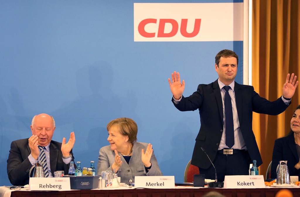 German Chancellor and leader of the Christian Democratic Union (CDU) party, Angela Merkel (C), applauds beside regional chairman Vincent Kokert (R) during a regional party conference in her home state of Mecklenburg Western Pomerania, in her first major a