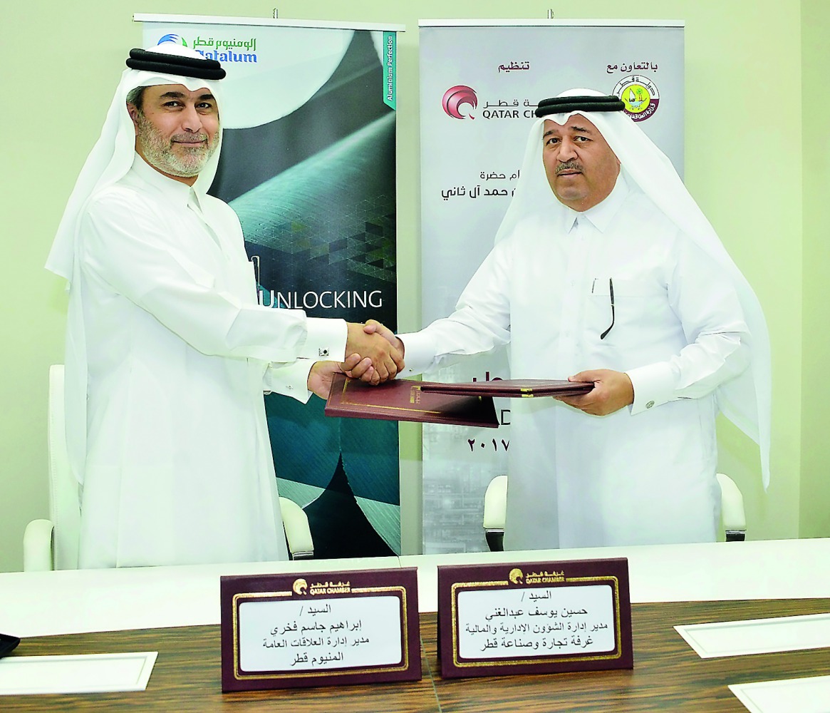 Hussain Yousef Al Abdul Ghani (right), Head of Administrative and Financial Affairs, Qatar Chamber; and Ibrahim Jassem Fakhri, Qatalum’s Communications Manager; shake hands after signing the sponsorship agreement at Qatar Chamber headquarters, yesterday.