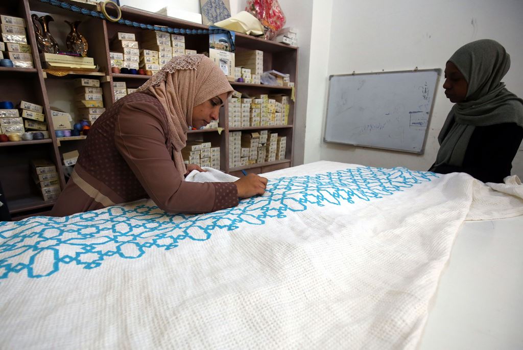A Palestinian woman embroiders at a workshop in Jordan's Jerash Palestinian refugee camp. AFP / KHALIL MAZRAAWI
