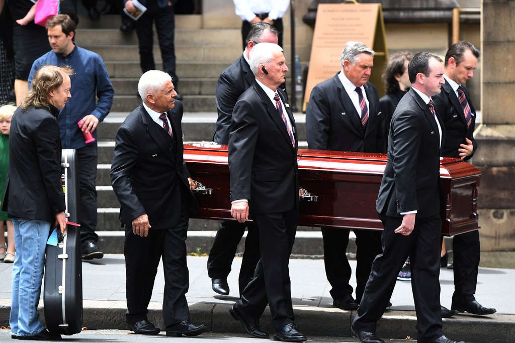 Angus Young holds a guitar as the casket of his brother AC/DC co-founder and guitarist Malcolm Young is carried to a hearse following his funeral at St. Mary's Cathedral in Sydney November 28, 2017. AAP/Dean Lewins/via Reuters 