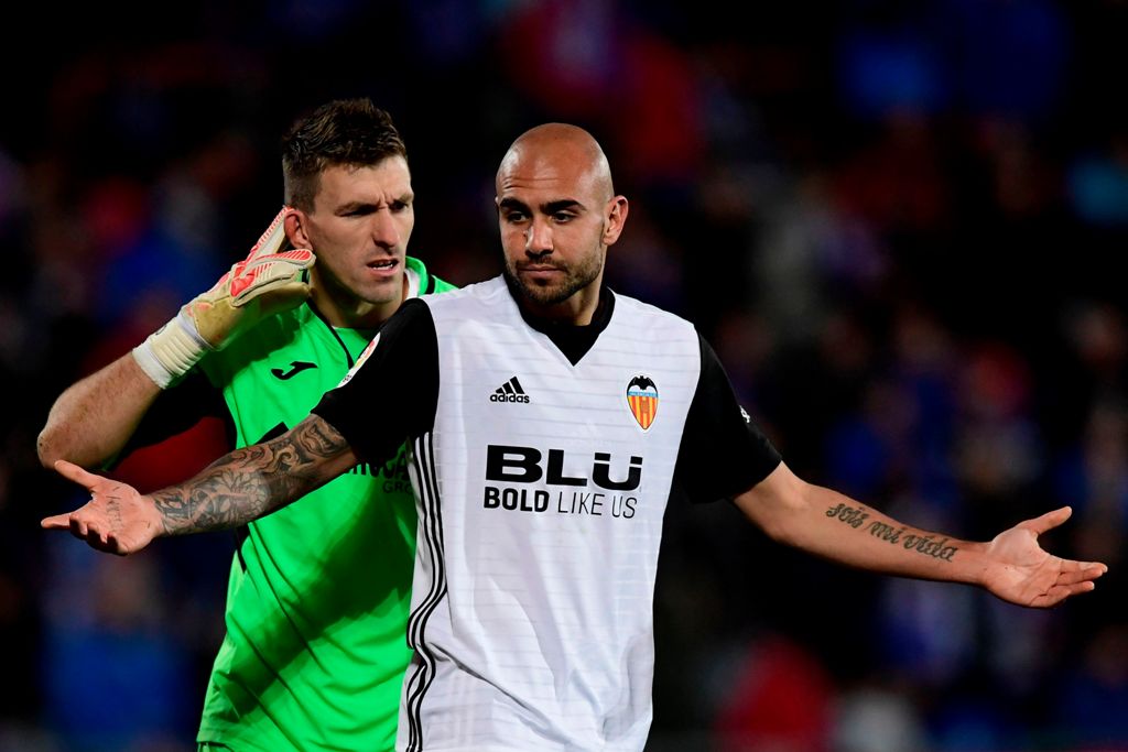Getafe's Spanish goalkeeper Vicente Guaita (L) reacts behind Valencia's Italian forward Simone Zaza after blocking his shot on goal during the Spanish league football match Getafe CF vs Valencia CF at the Col. Alfonso Perez stadium in Getafe on December 3