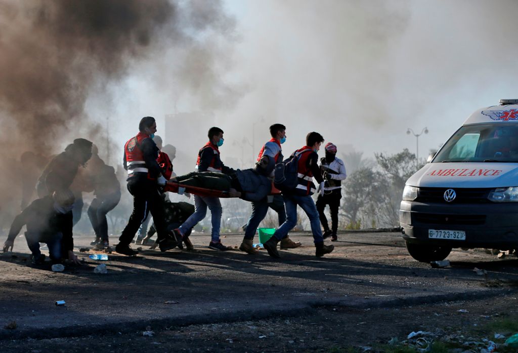 Palestinian protesters clash with Israeli troops near an Israeli checkpoint in the West Bank city of Ramallah on December 8, 2017. / AFP / ABBAS MOMANI